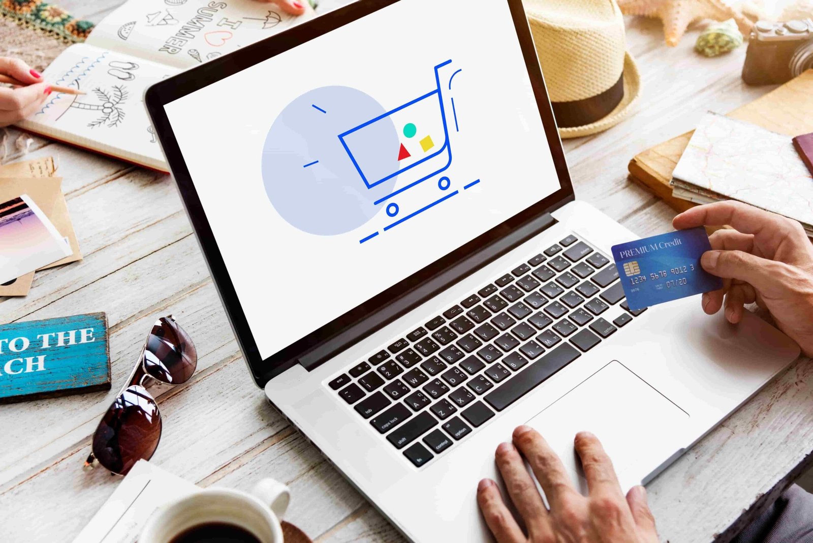 showing-cart-trolley-shopping-online-sign-graphic_courtest-freepik laptop showing a checkout screen with a hand holding a credit card